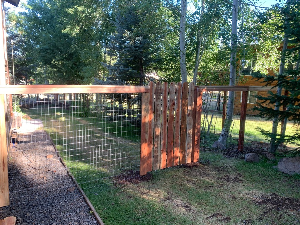 Redwood picket gate with wire fence